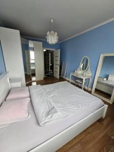 sypialnia z białym łóżkiem i niebieską ścianą w obiekcie Apartament Katowice Park Śląski w mieście Katowice