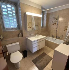 a bathroom with a toilet and a sink and a tub at Apartment Eldorado View in Lugano