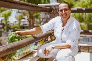a woman in white outfit sitting on a bench with lettuce at Hotel Ferdinando Beach & Thermal Spa in Ischia