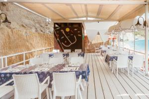 a restaurant with tables and chairs on a deck at Hotel Ferdinando Beach & Thermal Spa in Ischia