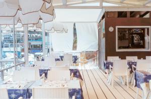 a dining room with white tables and white chairs at Hotel Ferdinando Beach & Thermal Spa in Ischia