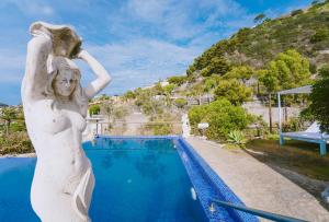 a statue of a woman standing next to a swimming pool at Hotel Ferdinando Beach & Thermal Spa in Ischia