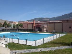 una gran piscina con una valla alrededor en Apartamento en Chalet La Rana Real, en La Granja de San Ildefonso