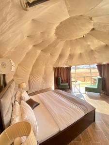 ein Schlafzimmer mit einem großen Bett in einem Zelt in der Unterkunft Rum Kingdom Camp in Wadi Rum