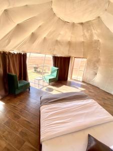 ワディ・ラムにあるRum Kingdom Campのテント内のベッドルーム(ベッド1台、椅子2脚付)