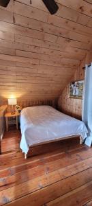 a bedroom with a bed in a wooden room at Ocean Views & Sunset Beach Cabin with soaker tub & fire pit in Powell River