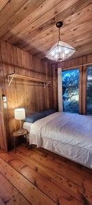 1 dormitorio con 1 cama en una cabaña de madera en Ocean Views & Sunset Beach Cabin with soaker tub & fire pit, en Powell River