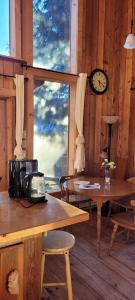 a room with tables and a clock on the wall at Ocean Views & Sunset Beach Cabin with soaker tub & fire pit in Powell River