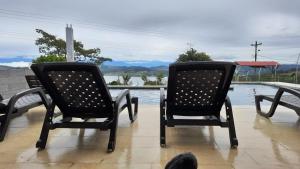 dos sillas negras sentadas junto a una piscina en Finca Las Aguas, en Calima