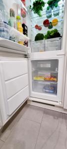an open refrigerator filled with food and vegetables at New Modern SelfCheckin PublicFreeParking HighSpeed Wifi KingSizeBed in Baden-Baden