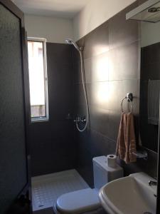 a bathroom with a shower and a toilet and a sink at apartment by the sea in Shëngjin