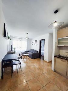a kitchen and living room with a table and a couch at Acogedor apartamento Besos de Elah in San Bartolomé