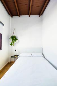 uma cama branca num quarto com tecto em madeira em Acogedor apartamento Besos de Elah em San Bartolomé