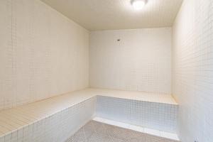 an empty room with white walls and blue tiles at Plantation East III in Gulf Shores