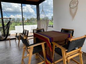 a dining room with a table and chairs and a hammock at Amazing house with private pool and beautiful view in San Miguel de Allende