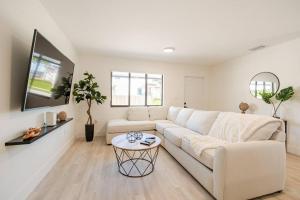 uma sala de estar branca com um sofá branco e uma mesa em The Pass Through Brand New 2 - 1 Modern Villa em Homestead