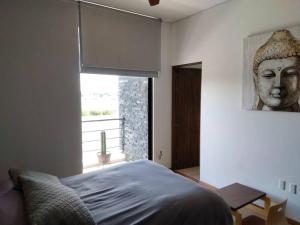 a bedroom with a bed with a statue of a head at Amazing house with private pool and beautiful view in San Miguel de Allende