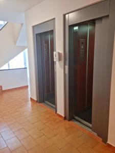 2 puertas de ascensor en un pasillo con suelo de baldosa en Paraíso!, en Matalascañas