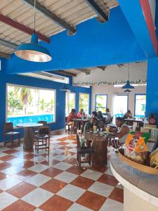 pessoas sentadas a mesas num restaurante com tectos azuis em Villa Bella em Portobelo