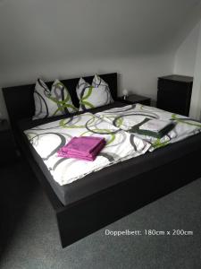 a bed with a black and white blanket and pillows at Anbau in Evestorf