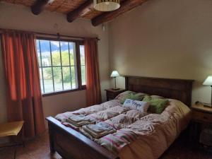 a large bed in a bedroom with a window at Cabañas Inti Raymi in Huacalera