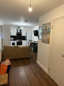 ein Wohnzimmer mit einem Sofa und einer Küche in der Unterkunft Beautiful- Dream Ground Floor one bedroom apartment in London