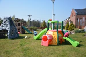 two children playing on a playground in the grass at Bazuny Hotel&Spa in Kościerzyna