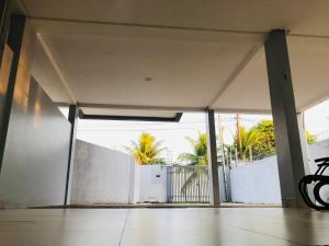uma garagem aberta com uma cerca branca e palmeiras em Casa em bairro nobre - Caçari em Boa Vista
