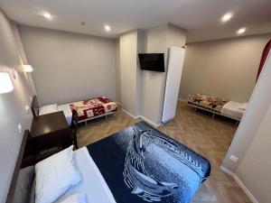 a small room with two beds and a tv at Hipotel Paris Printania Maraichers in Paris