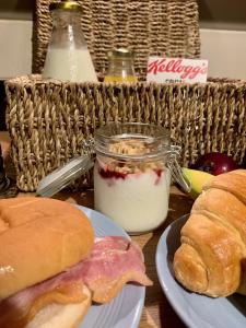 a table with a sandwich and a jar of yogurt and bread at Bella Vista in Paignton