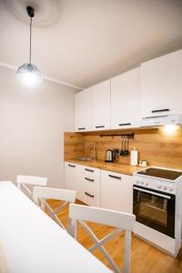uma cozinha com armários brancos e um forno com placa de fogão em Krijesnica 