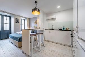 een keuken en een slaapkamer met een bed in een kamer bij Oporto Wine Cellars Flat With Terrace in Vila Nova de Gaia