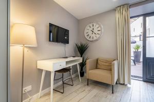 een kamer met een bureau, een klok en een stoel bij Oporto Wine Cellars Flat With Terrace in Vila Nova de Gaia
