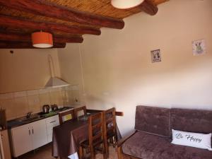a kitchen with a table and a couch in a room at Cabañas Inti Raymi in Huacalera