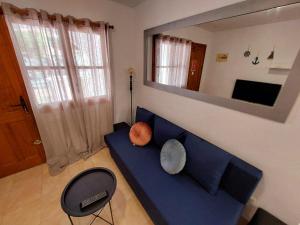 - un salon avec un canapé bleu et un miroir dans l'établissement Apartament Casa del Gato Rojo , communal swimming pool , terrace with barbecue, à Torrevieja
