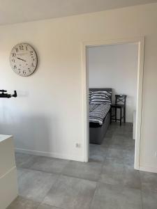 een kamer met een klok aan de muur en een bed bij Apartament Cieplice in Jelenia Góra