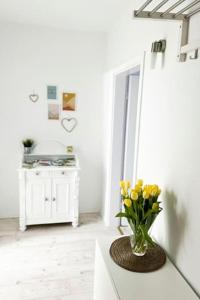 a vase of yellow flowers on a counter in a room at Modernes Apartment mit Balkon free Parking Netflix in Celle