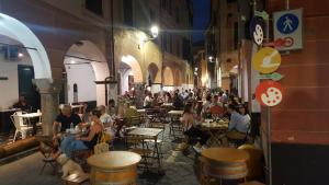 a group of people sitting at tables in an alley at La Terrazza del Borgo in Lavagna