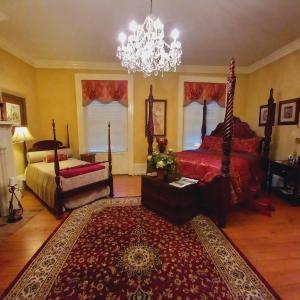 a bedroom with a bed and a chandelier at Governor's Corner Bed & Breakfast in Russellville
