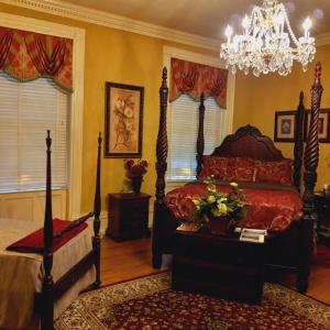 1 dormitorio con cama y lámpara de araña en Governor's Corner Bed & Breakfast en Russellville