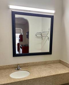 a mirror above a sink in a bathroom at American Way Inn & Suites in Memphis