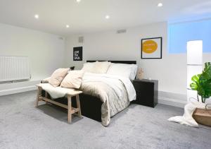 1 dormitorio con 1 cama grande y 1 silla en Stylish 3 bed flat with Garden, en Londres