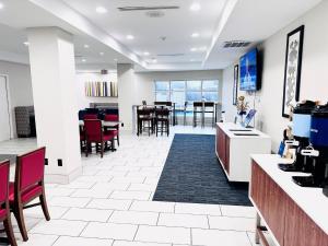 an office lobby with red chairs and tables at Holiday Inn Express & Suites Houston East - Baytown, an IHG Hotel in Baytown