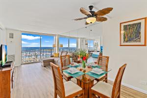 a dining room and living room with a table and chairs at Stunning 1BR Ocean View Condo at Ilikai Marina in Honolulu