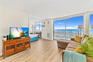 a living room with a flat screen tv and a couch at Stunning 1BR Ocean View Condo at Ilikai Marina in Honolulu