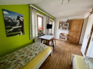 una camera da letto con pareti verdi, un letto e un tavolo di Im- Oberland - Berg - KönigsCard a Bad Kohlgrub