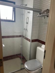 uma casa de banho com um WC e uma cabina de duche em vidro. em Flat super equipado em São Paulo