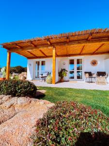 a home with a wooden pergola and a patio at B&B Anastasia in Santa Teresa Gallura
