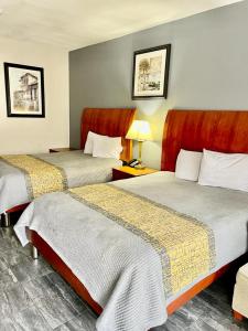 a hotel room with two beds and a lamp at American Way Inn & Suites in Memphis