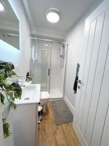 La salle de bains est pourvue d'un lavabo blanc et d'une douche. dans l'établissement Homes from home by Tulloch Properties, à Maidstone